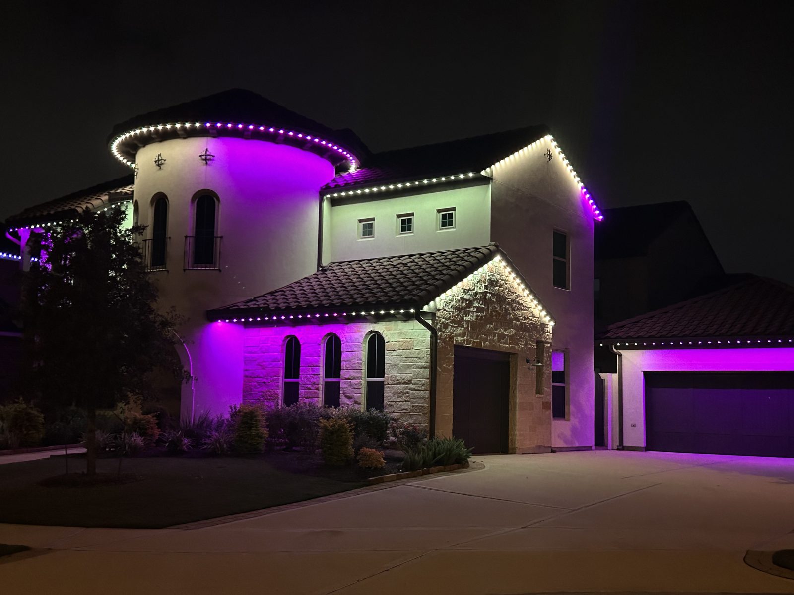 Permanent roofline lighting on a Mediterranean home showing a purple color mode